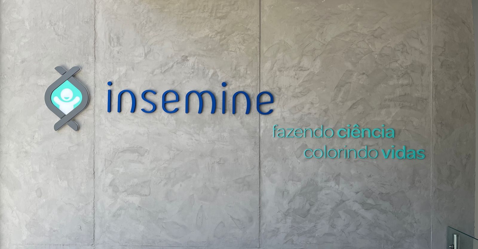 Parede com a marca da Clínica Insemine — fazendo ciência, colorindo vidas